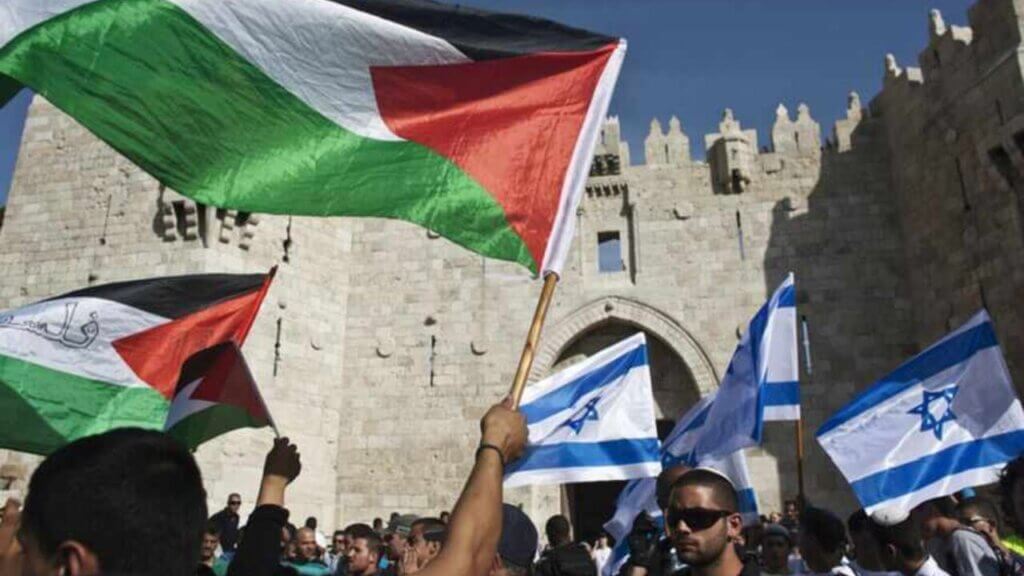 Palestinian protesters wave Palestinian flags as Israelis carrying Israeli flags walk past in front of the Damascus Gate outside Jerusalem's Old City during a parade marking Jerusalem Day May 8, 2013. Jerusalem Day marks the anniversary of Israel's capture of the Eastern part of the city during the 1967 Middle East War. In 1980, Israel's parliament passed a law declaring united Jerusalem as the national capital, a move never recognised internationally. There were confrontations on Wednesday between Muslims and Jews outside Jerusalem's walled Old City, where al-Aqsa mosque is located. Police arrested 10 Palestinians, police spokesman Micky Rosenfeld said. REUTERS/Nir Elias (JERUSALEM - Tags: POLITICS CIVIL UNREST ANNIVERSARY) - RTXZF09